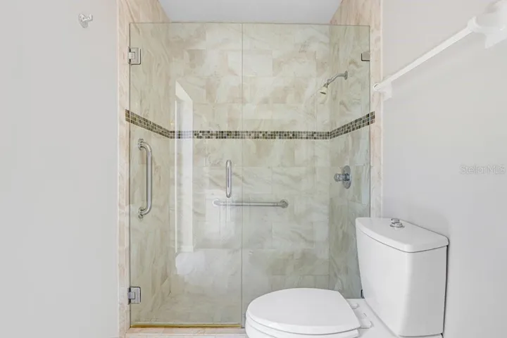 Renovated primary shower with new seamless shower glass door