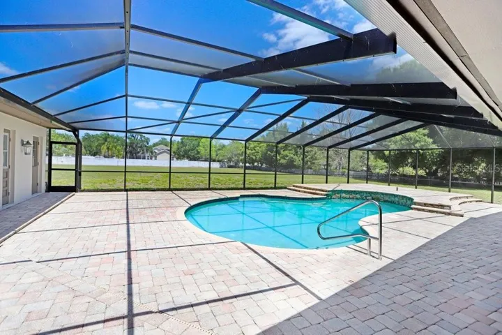Beautiful pavers around the pebble tech pool and new pool cage