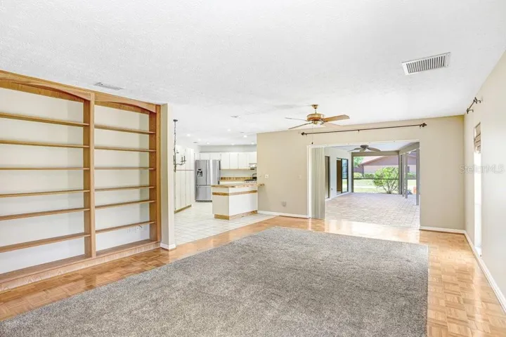Family Room with wood burning fireplace and built in book shelves and view into kitchen