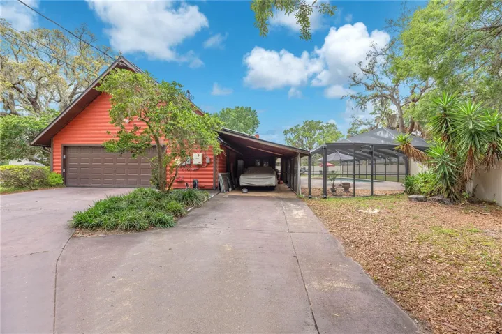 An attached single carport, a two-car side-entry garage, and an extended driveway provide ample room for multiple vehicles, boats, or RVs.