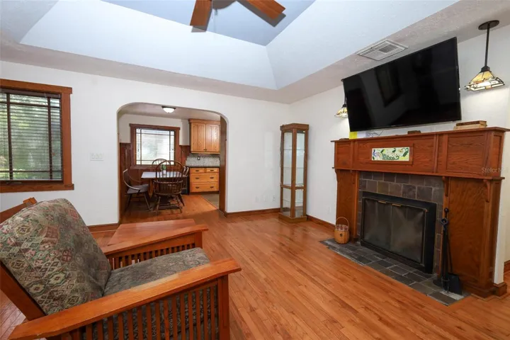 All wood floors with access to kitchen/dining area with cove ceiling and arched doorways