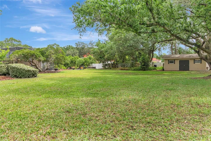 Expansive backyard with mature trees and a 12x20 storage building-offering plenty of space for gardening, hobbies, or additional storage.