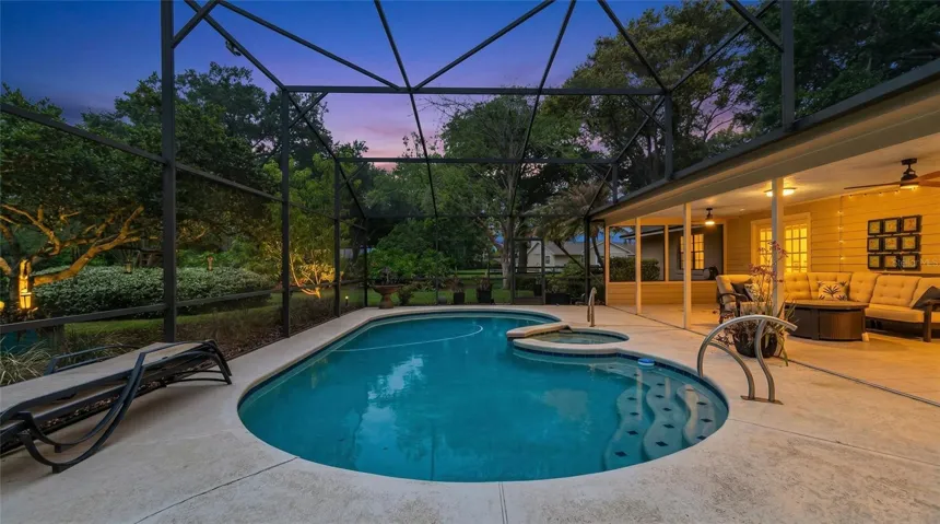 Breathtaking resort-style pool and spa within a screened enclosure, complemented by a covered outdoor living area--designed for elegant entertaining and serene evenings.