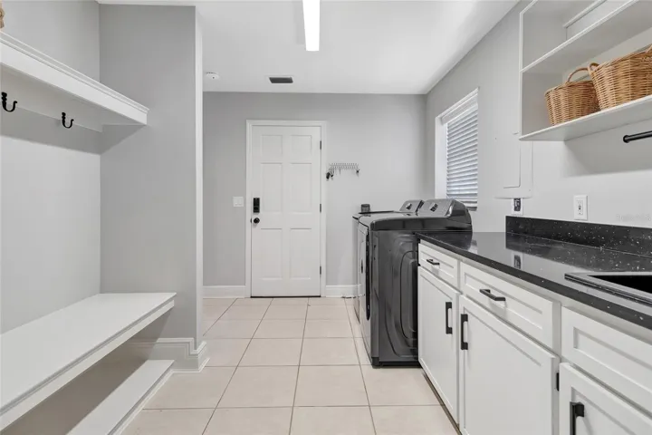 Spacious laundry room with abundant cabinetry, folding counter space, and built-in mudroom area for added organization.
