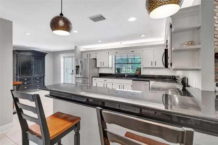Stunning open kitchen showcasing an oversized breakfast bar, granite countertops, and a flexible layout with space for a breakfast table-designed for effortless entertaining.