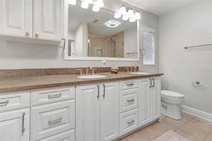 Spacious primary bath featuring dual vanities, abundant cabinetry, and a bright, functional layout.