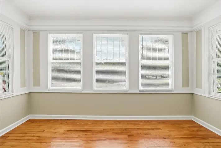 Bright sunroom offers flexible space for a den, office, reading room, or creative retreat.