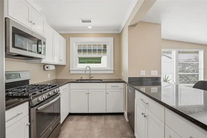 Updated kitchen with stainless steel appliances and stone countertops.