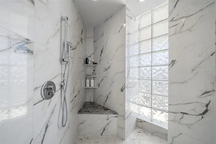 Glass-enclosed shower with custom mosaic tilework