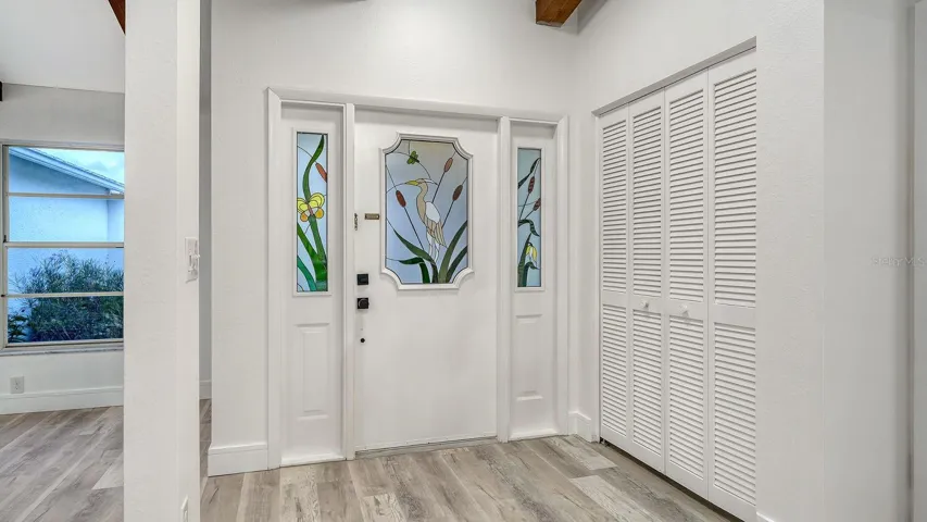 Inviting Foyer with a Metal Door & Attractive Stained Glass Inserts