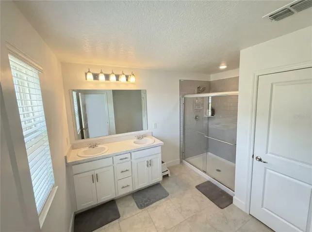 Primary bathroom with modern finishes and functional layout.