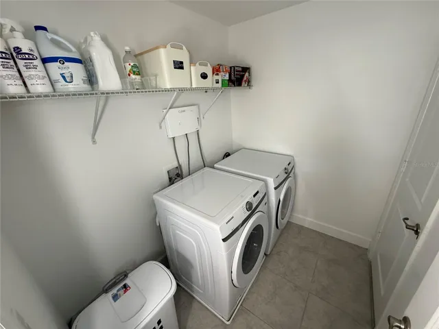 Dedicated laundry room with washer and dryer and additional storage space.