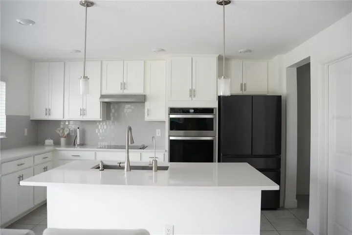 Gourmet-style kitchen featuring quartz countertops, stainless stell appliances and oversized island