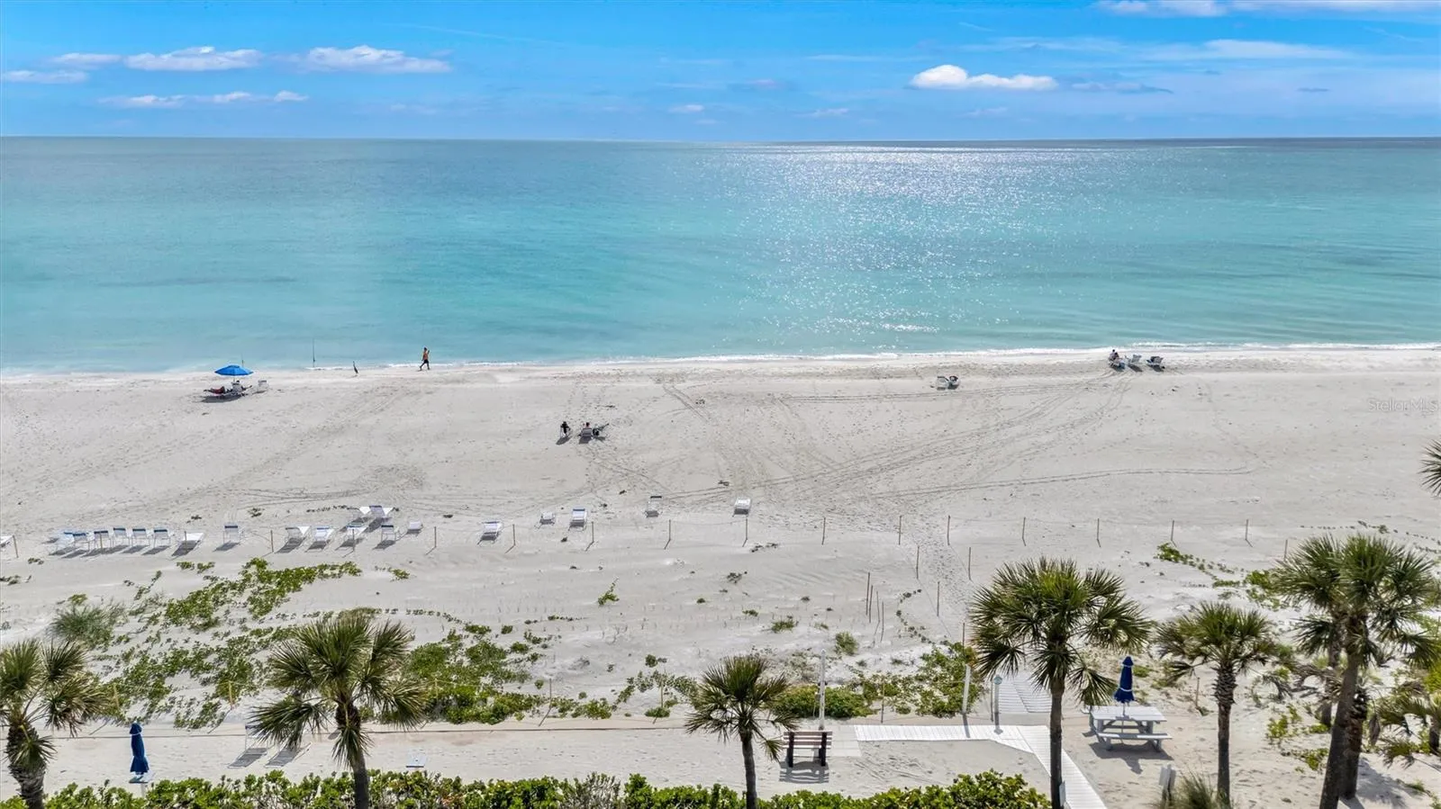 Actual photo of the Beach Harbor Club’s exclusive beach  facility with Tiki huts and bar-b-que. plenty of chaise lounge seating. Also has a fresh water shower beachside