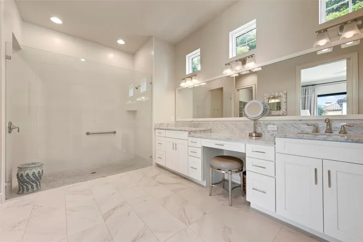 Primary bathroom with huge walk-in shower, marble countertops, tall countertops