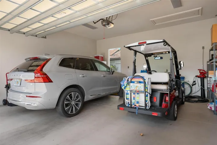 Two car garage, hurricane impact garage door, electric Volvo Crossover and street legal cart