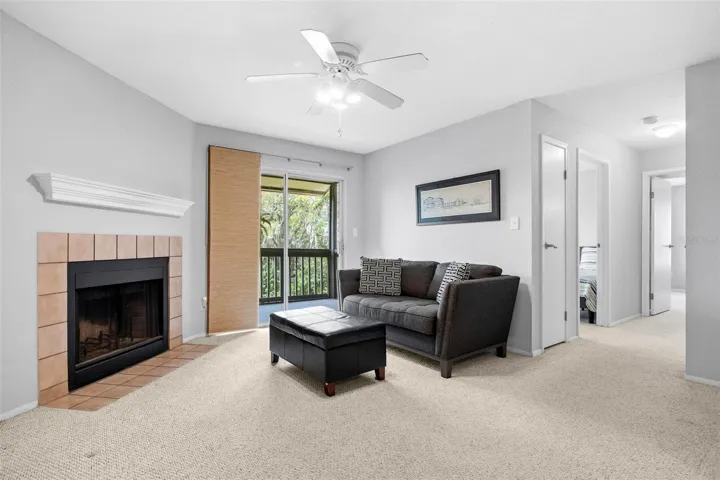 Living Room with Wood Burning Fireplace and Sliding Glass Doors to Screened Porch