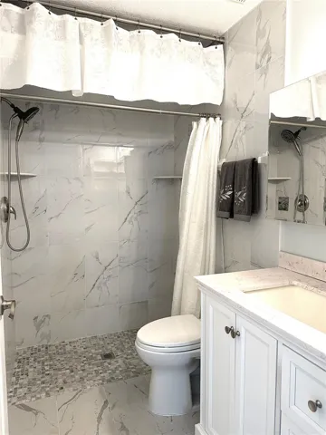 Guest Bathroom with Upgraded Toto toilet and storage above shower