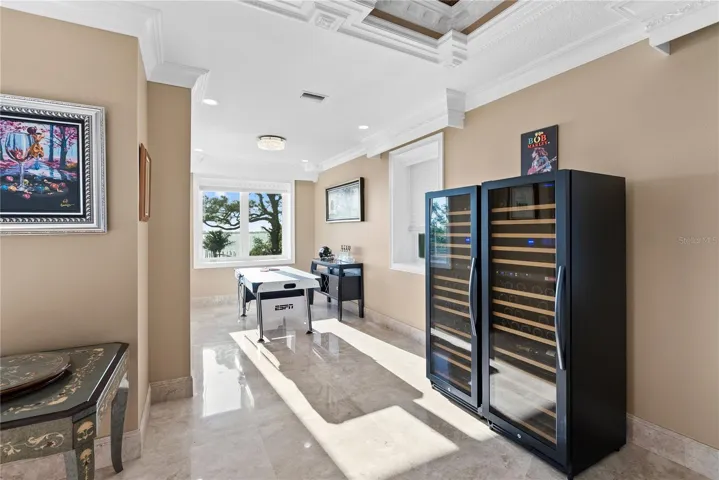 Expansive room with two ornate coffered ceilings—perfect for a pool table or game lounge.