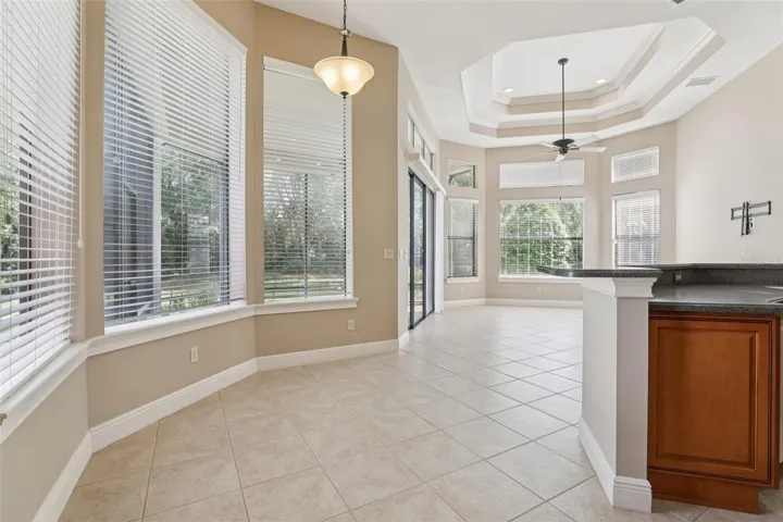 Kitchen dining area / leading to Family room with 12 ft high ceilings with triple trays and recessed lighting, spacious and light and bright