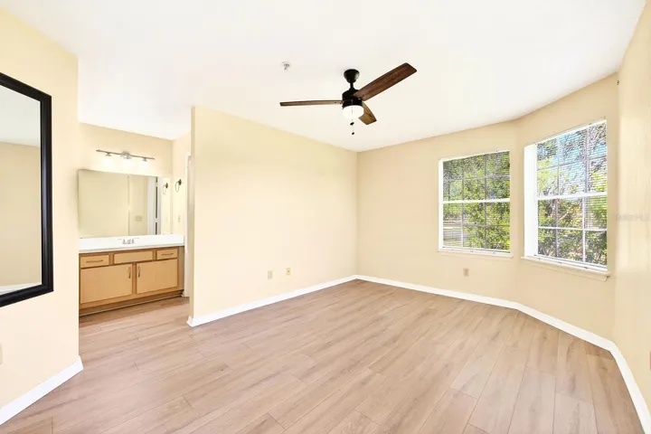 The Primary Bedroom continues the theme of comfort and views, featuring wood-look vinyl flooring, a walk-in closet, and PRIVATE ACCESS to the full bath.