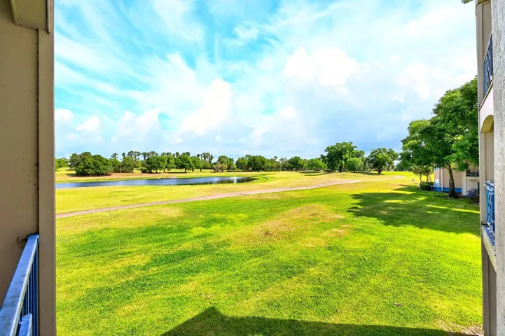 Sliding glass doors lead to a PRIVATE BALCONY, offering stunning elevated views of the golf course and water—the perfect spot to unwind or enjoy your morning coffee.