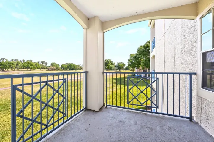 Sliding glass doors lead to a PRIVATE BALCONY, offering stunning elevated views of the golf course and water—the perfect spot to unwind or enjoy your morning coffee.