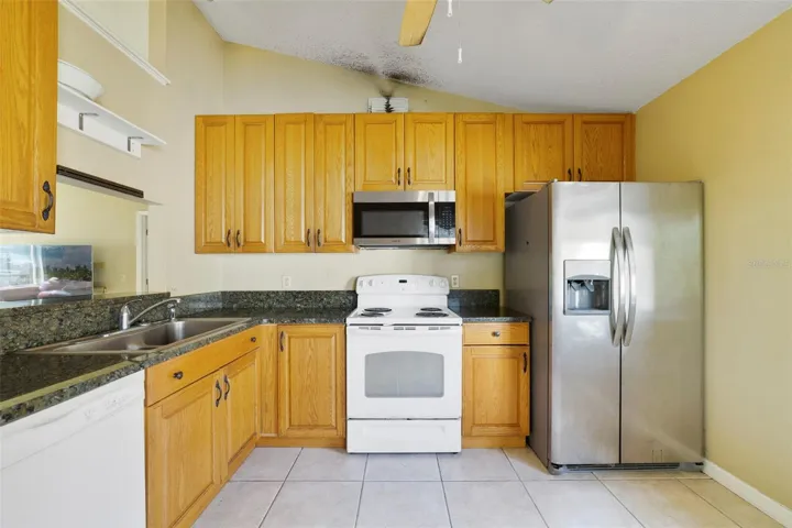 The Kitchen features ample cabinetry and solid surface countertops for meal prep and storage.