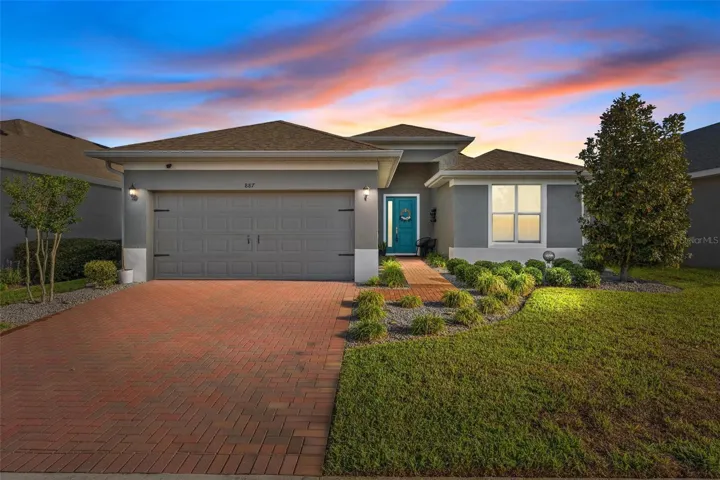 Front of home showing brick paver drive and sidewalk to front door