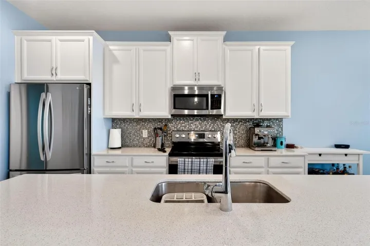 Staggered cabinets with crown molding and panel giving fridge its own built in area