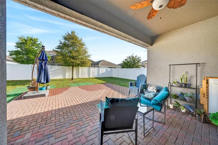 Rear brick paver patio with view of private fenced yard
