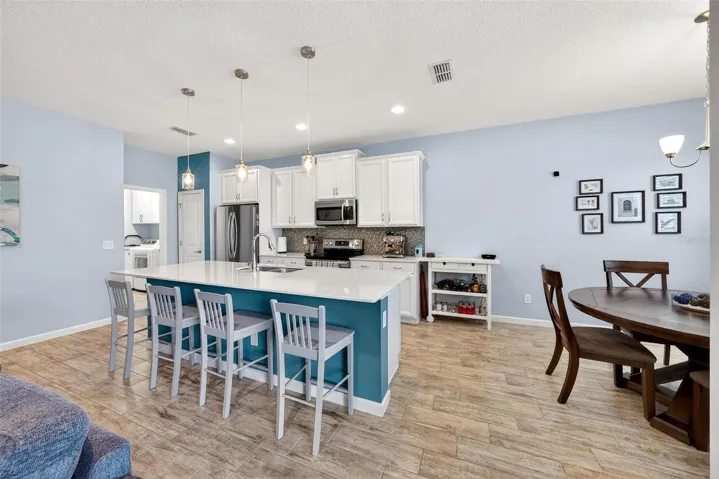 Dining area to right with view of fenced backyard