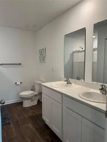 En suite bathroom with dual sinks, shower and linen closet
