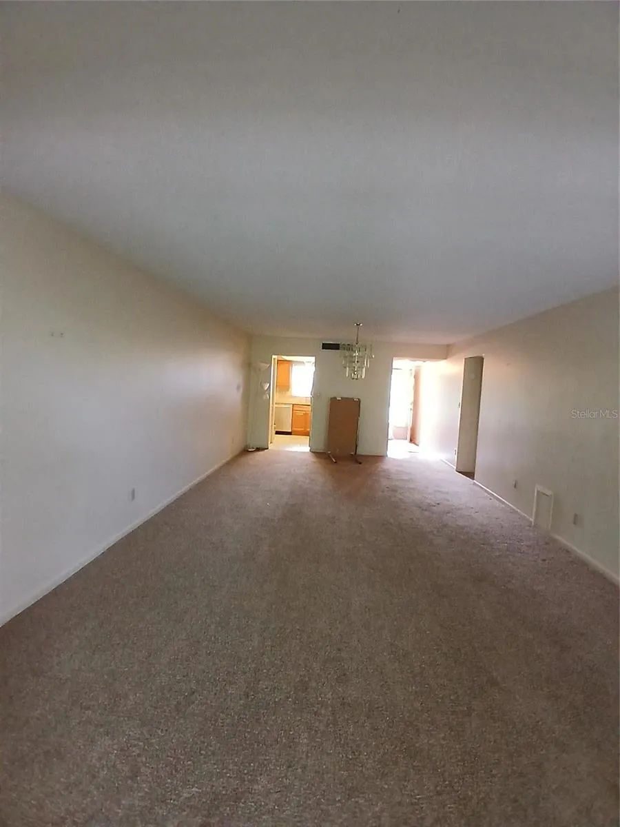 View of the living room looking toward the kitchen, dining area and front hall.