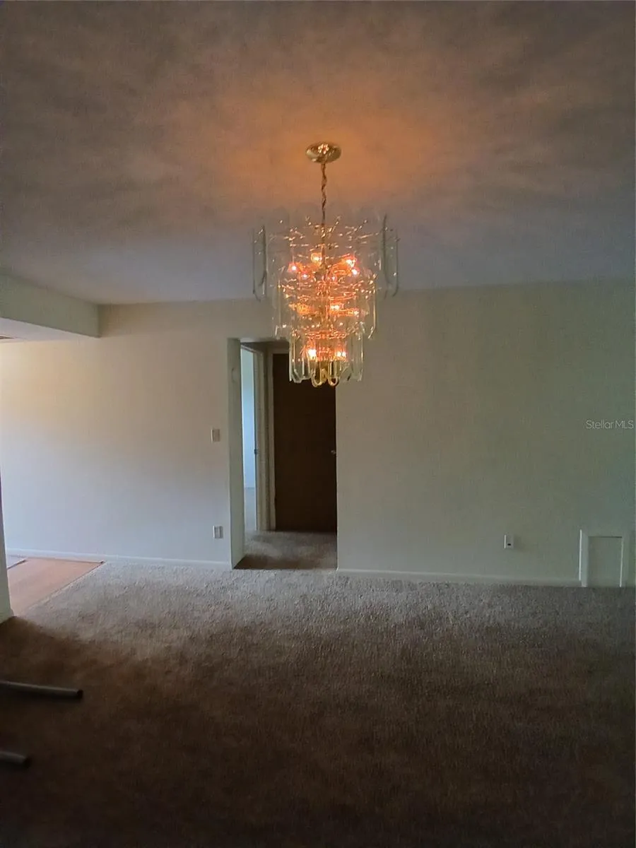 Dining area with over the table chandelier right outside of the kitchen.