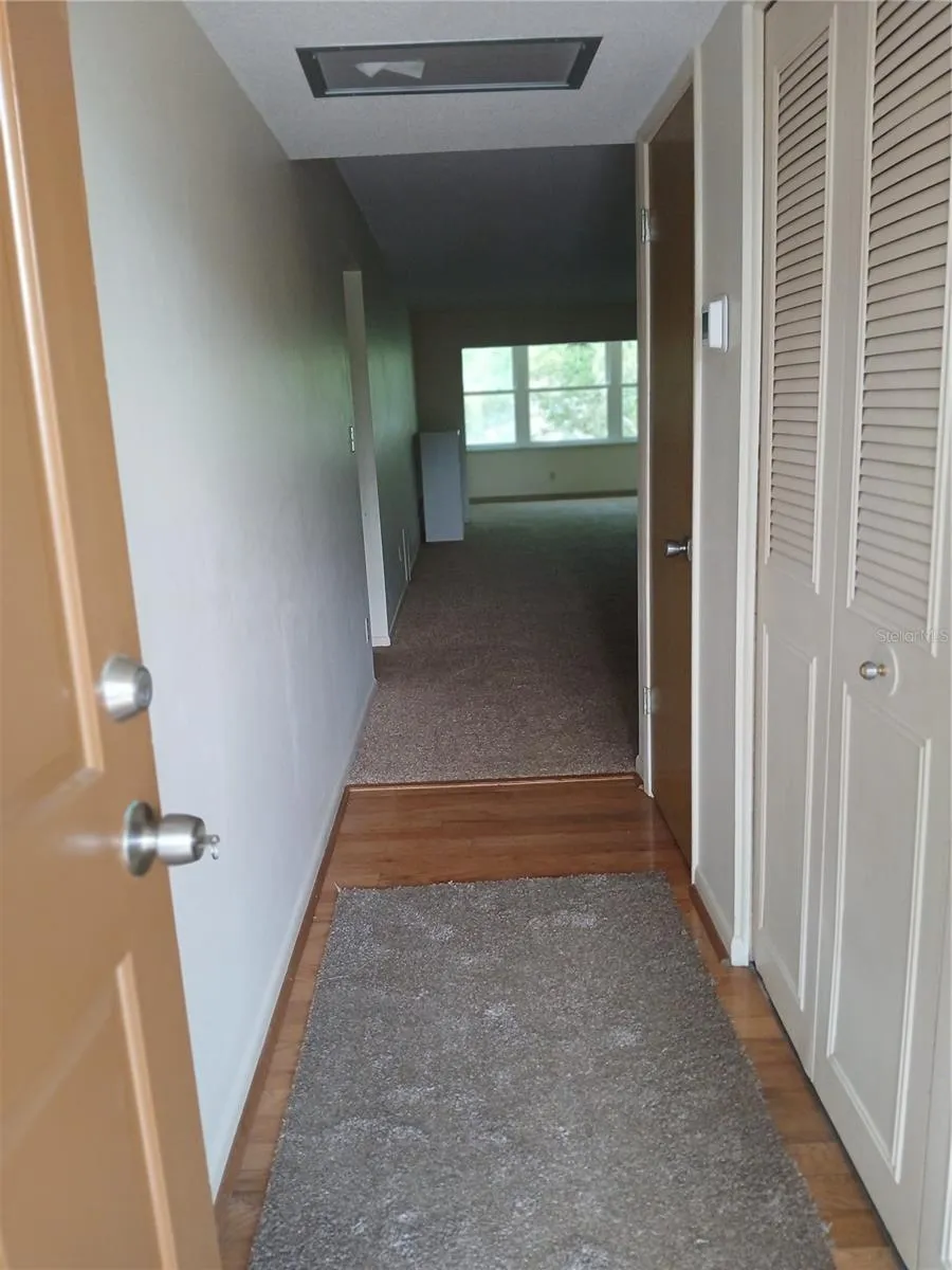 Entry hallway with wood floor and a 2 door closet, The air handler is in the front of the closet.