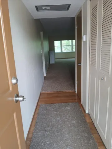 Entry hallway with wood floor and a 2 door closet, The air handler is in the front of the closet.