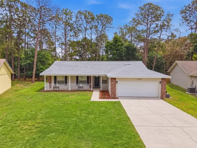 Beautifully maintained home featuring a welcoming front porch and spacious front yard.