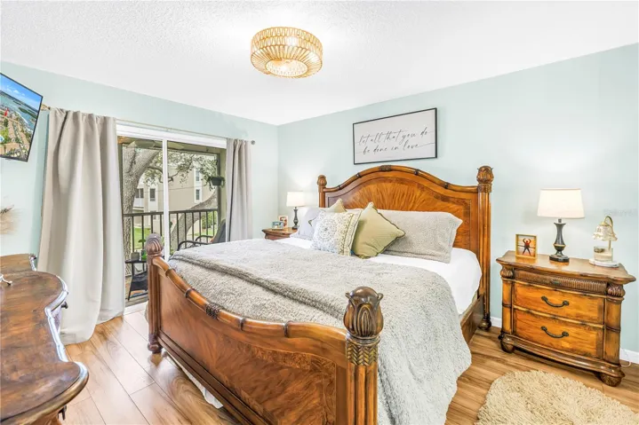 master bedroom with sliding glass door to outside screened in balcany