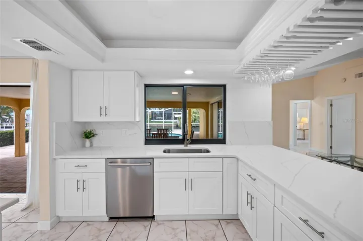 Kitchen overlooks the lanai, pool and canal