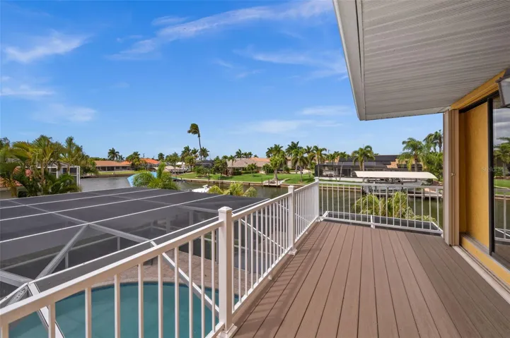 Upstairs Primary balcony with views of the pool and canal