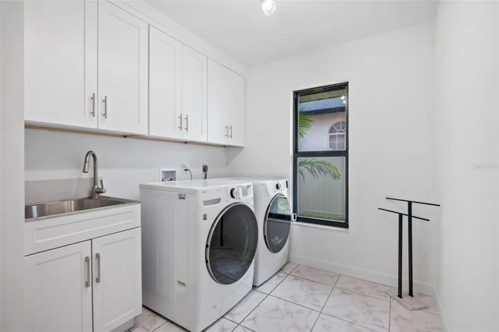 Huge Indoor laundry room with lots of cabinets and laundry sink