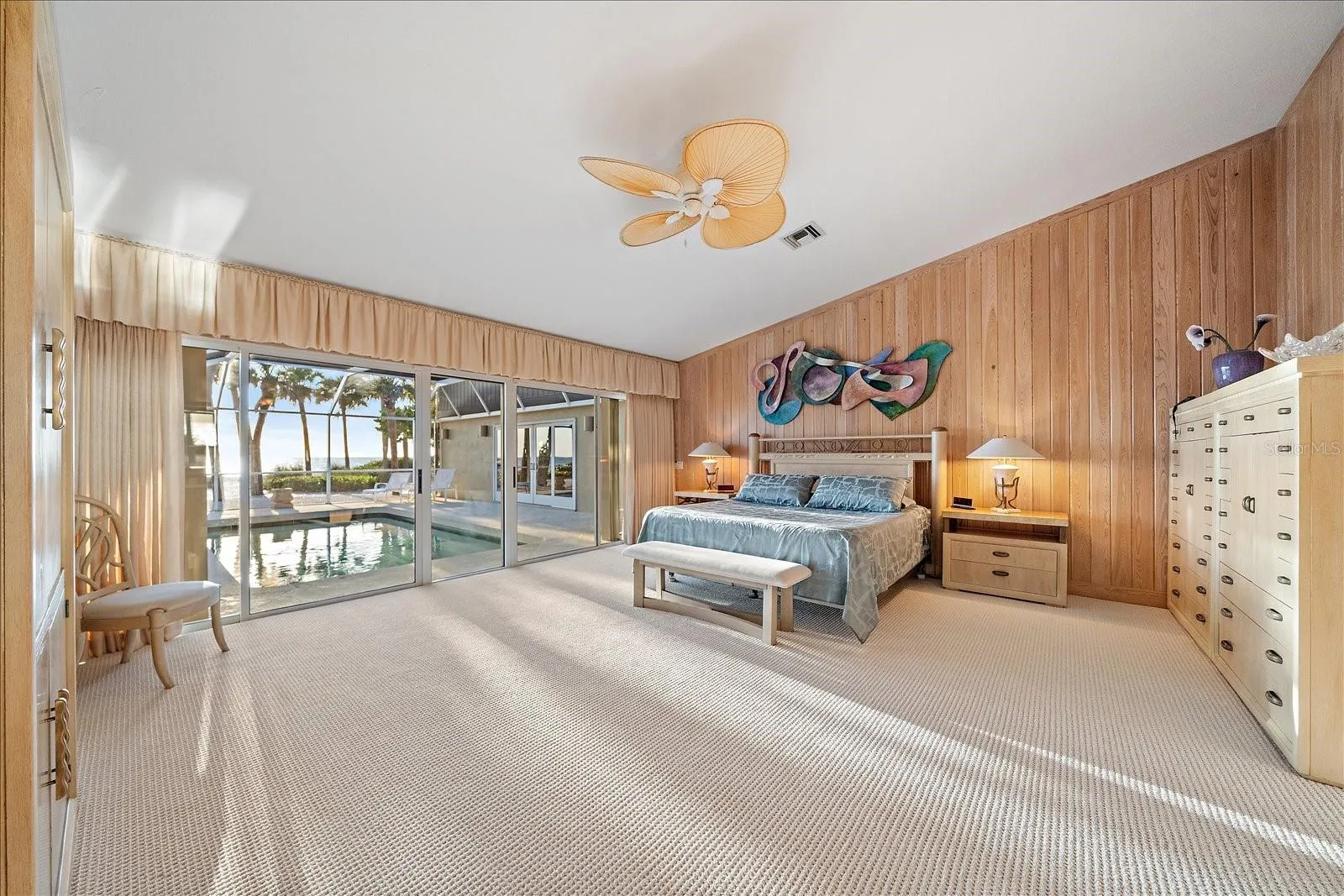 PRIMARY BEDROOM with gulf and pool access through the sliding glass doors