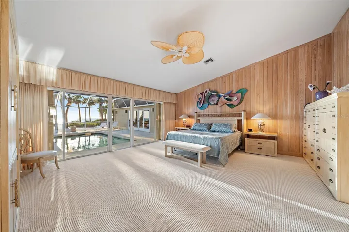 PRIMARY BEDROOM with gulf and pool access through the sliding glass doors