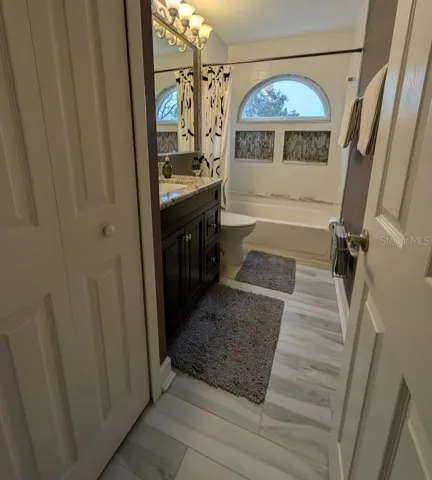 Remodeled hall bath with new tub, vanity, tile and lighting. Features linen closet