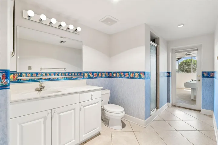 Basement full bathroom with walk-out access to the pool deck.