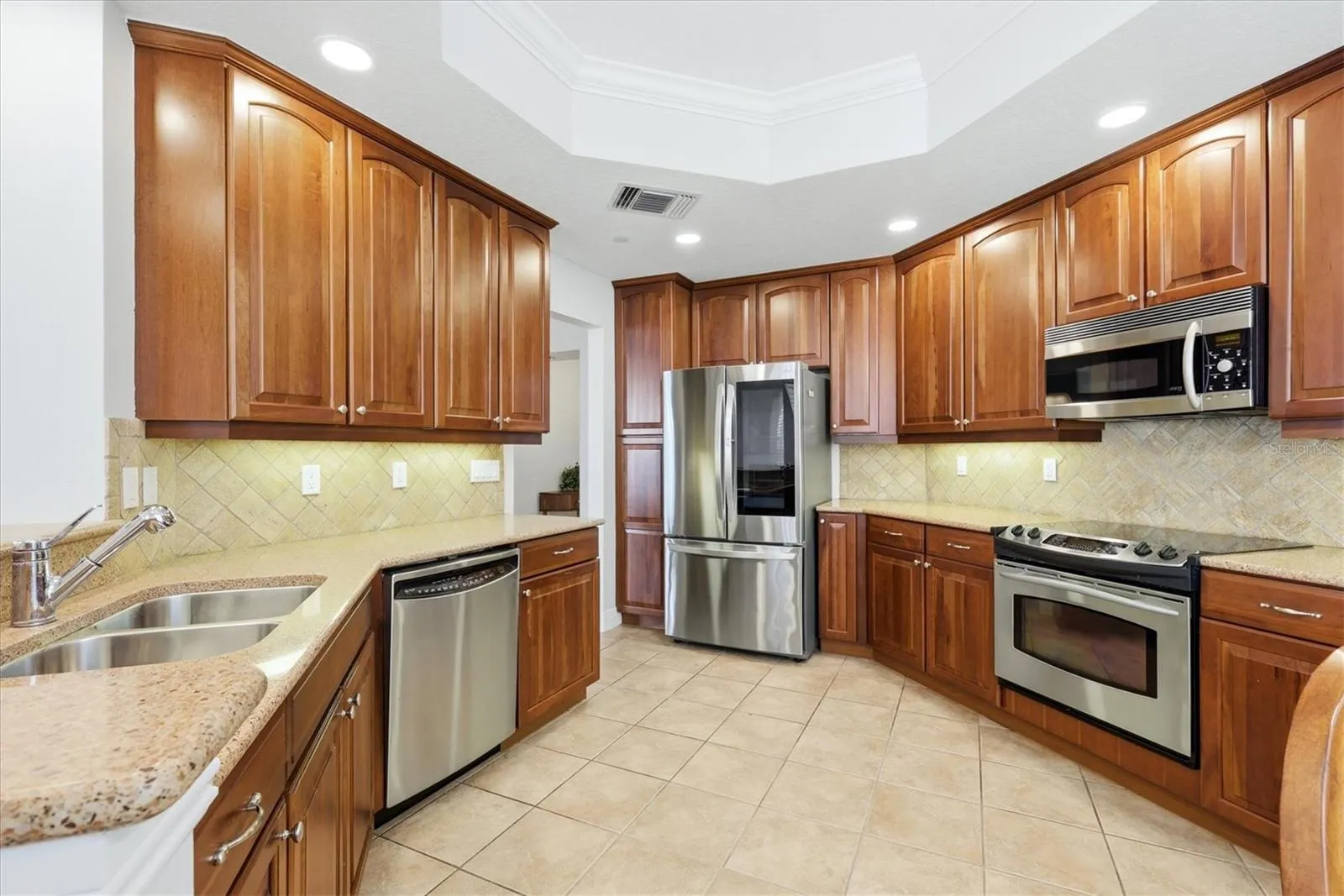 Tall wooden cabinetry, stainless appliances and granite countertops