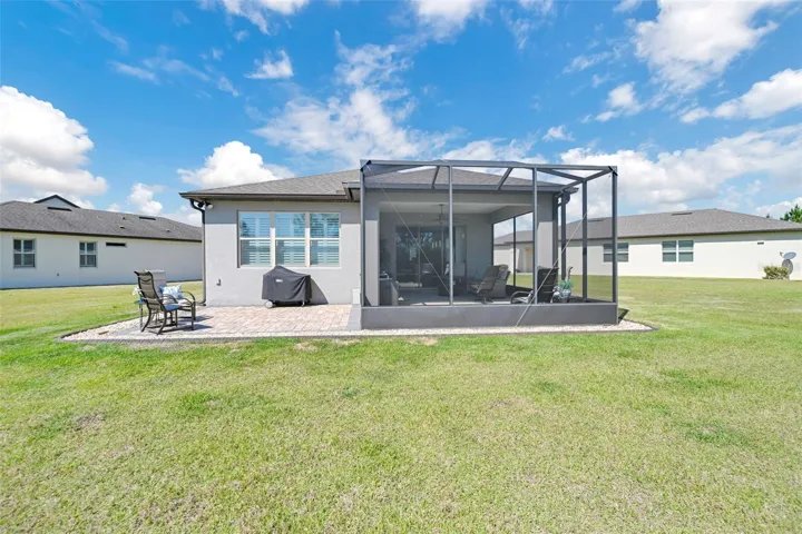 Rear View of Home w/ Extended Screened Lanai + Cage + Open Paver Patio