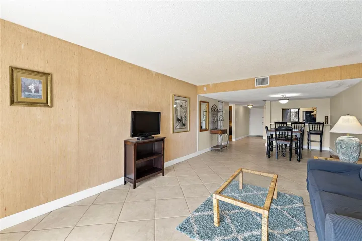 Full-depth living and dining layout with tile flooring and sliding glass door to patio