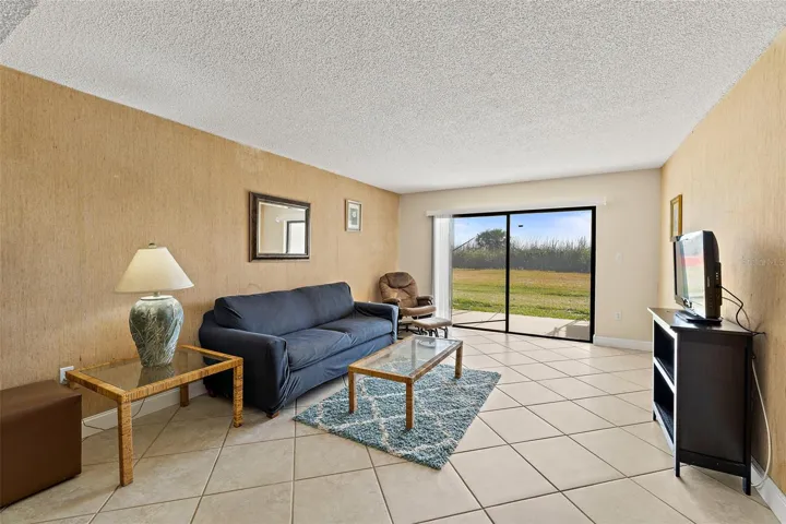 Living room with tile flooring, sliding glass door, and ground-level views of protected sea turtle habitat